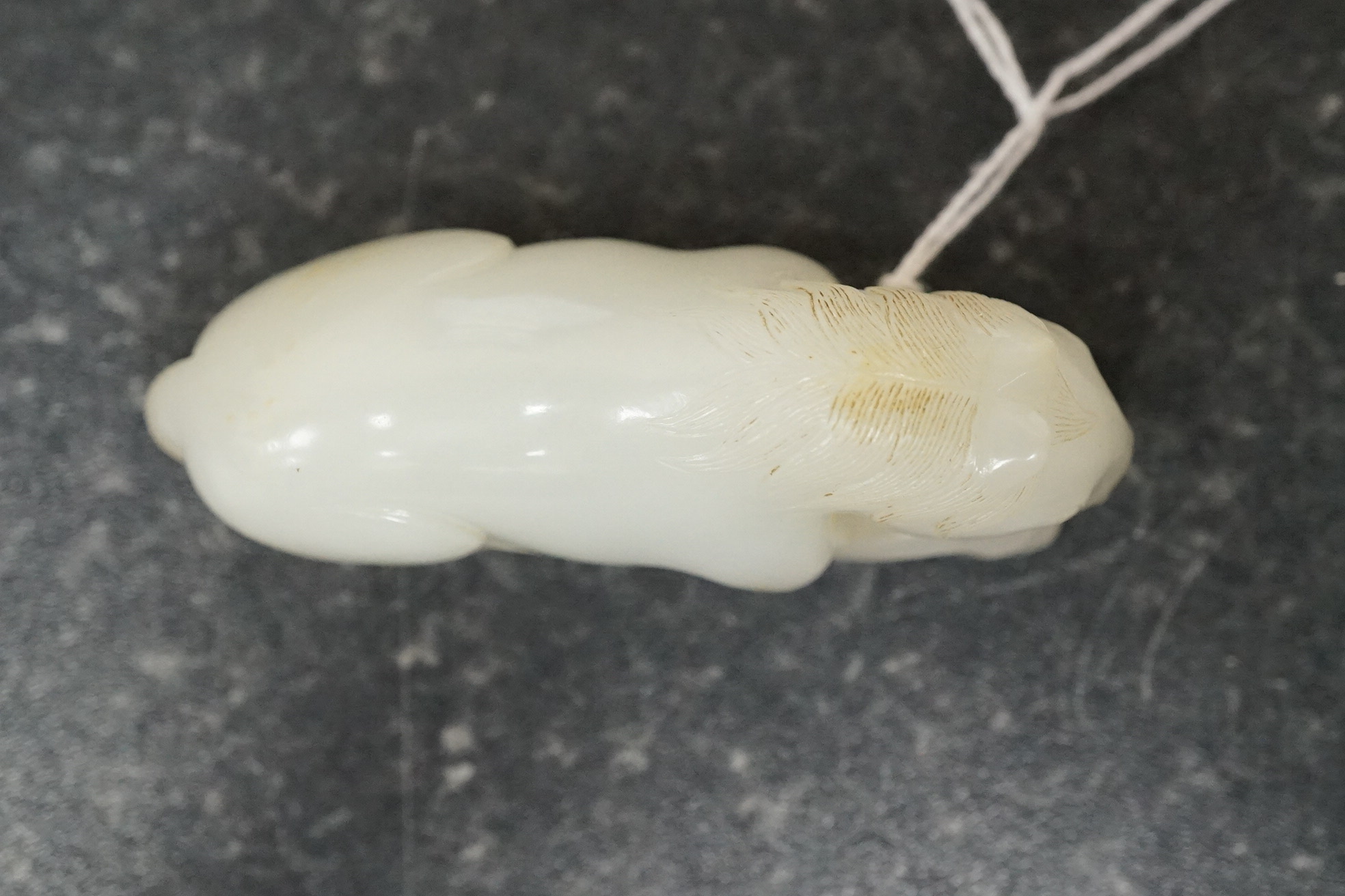 A Chinese white jade figure of a recumbent horse